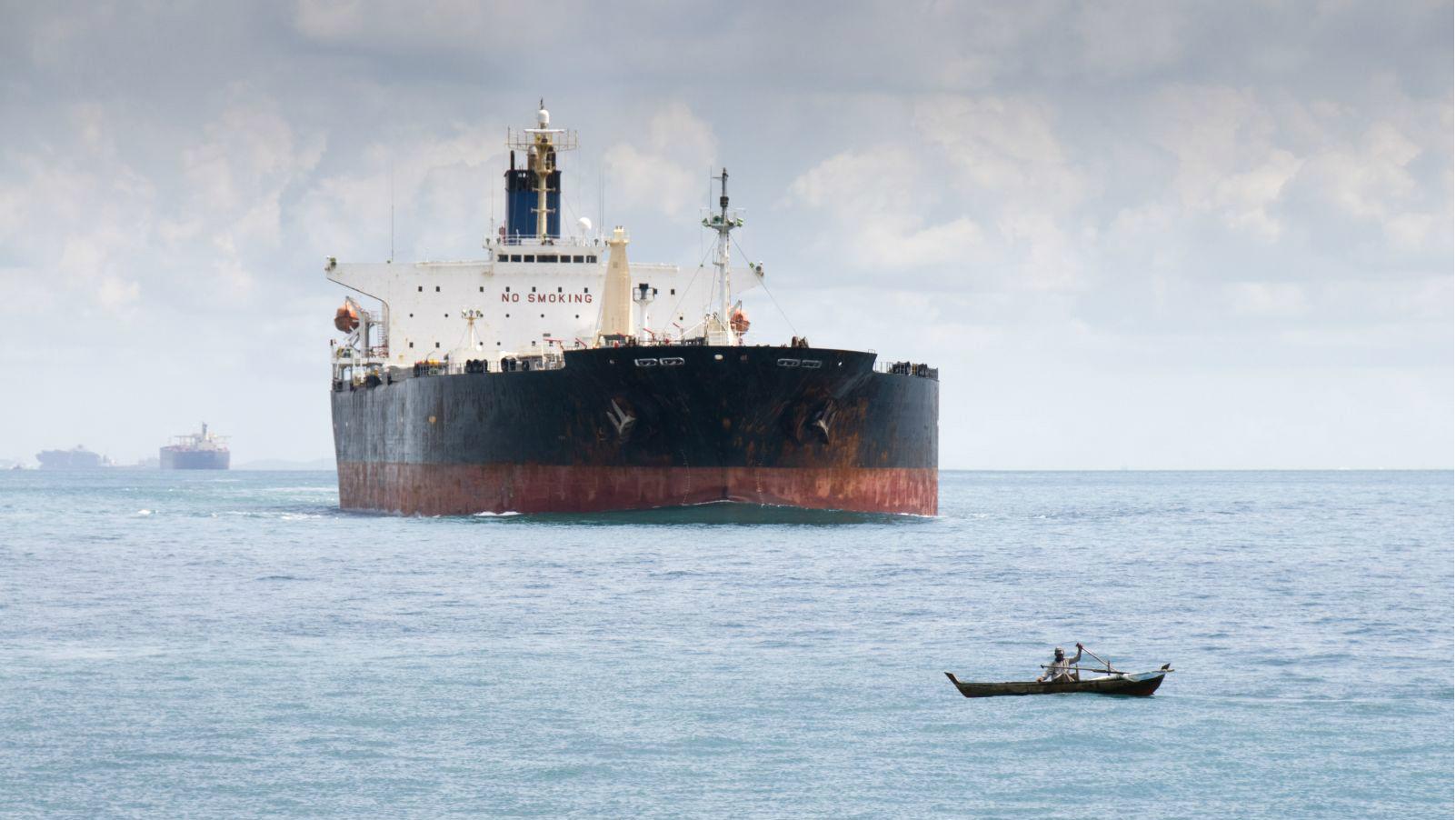 Small boat in front of tanker
