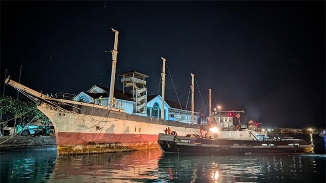 historic sailing ship being towed away