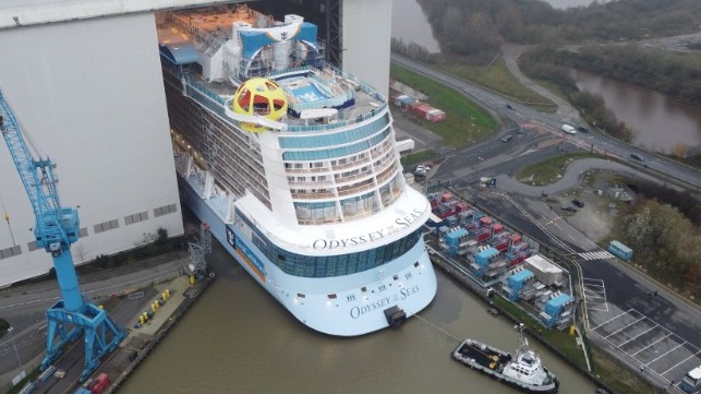 large cruise ship emerges from building hall