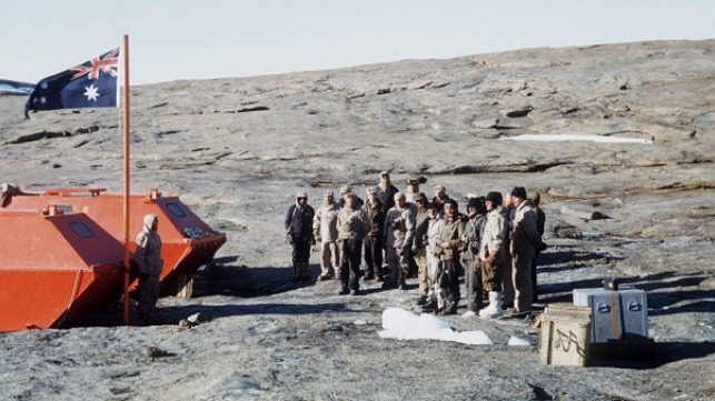 The Australian flag is raised by Dr Phillip Law at the naming of Mawson research station in February 1954. (Photo: R Thompson)