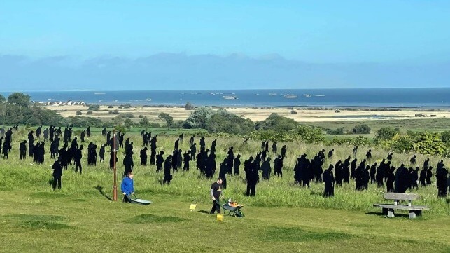 CWGC staff prepare the British Normandy Memorial grounds for June 6. In the background, handmade silhouettes of Allied soldiers "advance" over the hillside, May 2024 (Royal Navy)