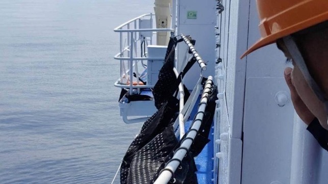 A crewmember inspects a damaged railing aboard a Philippine Coast Guard vessel after a Chinese water-cannon attack, April 30 (PCG)