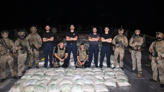 Marines and sailors aboard HMS Lancaster show the haul of hashish they seized from a dhow (Royal Navy)