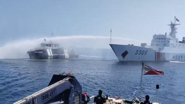 A China Coast Guard vessel water-cannons a Philippine government vessel. The Chinese government claims it reached a secret deal for a "new model" for these interactions (PCG file image)