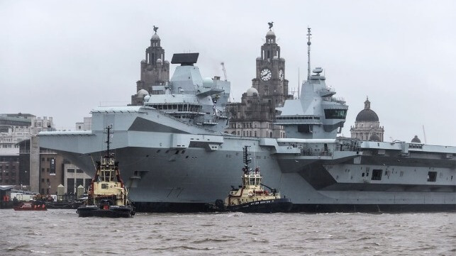 tugs assisting aircraft carrier
