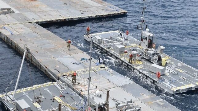 U.S. Army soldiers assemble a JLOTS floating causeway in a mobilization exercise off Australia. The cost of the operation was absorbed for training purposes (U.S. Army)