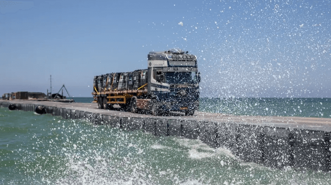 Maritime Aid Pier Installed in Gaza for the Third Time A truck rolls down the floating causeway in modest swells, June 11 (U.S. Army)