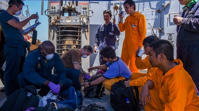 U.S. Navy sailors provide aid to the crew of Kokuka Courageous onboard USS Bainbridge