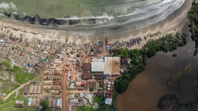 An aerial view of a fishmeal plant near a beach in The Gambia