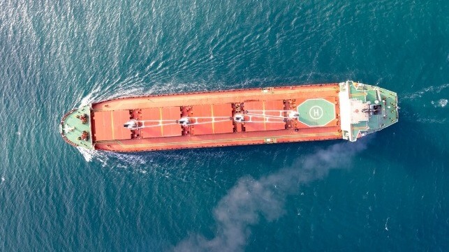 Bulker with smoke from stack viewed from above