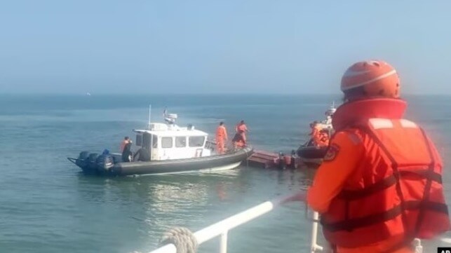 Taiwan Coast Guard Administration personnel inspect the capsized Chinese speedboat (CGA handout)