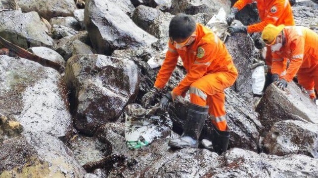 PCG response workers mopping oil off rocks