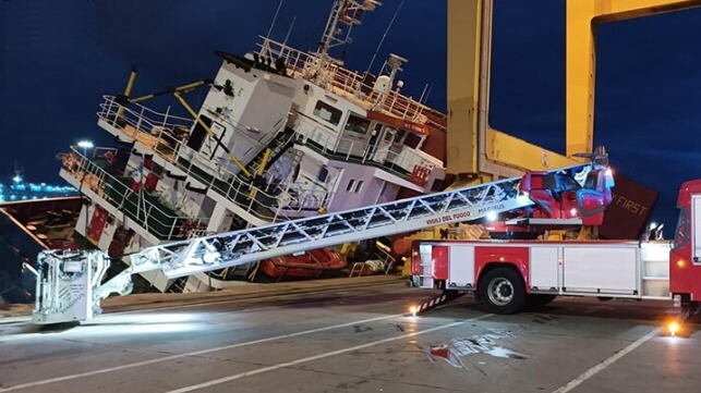 cargo ship listing against dock