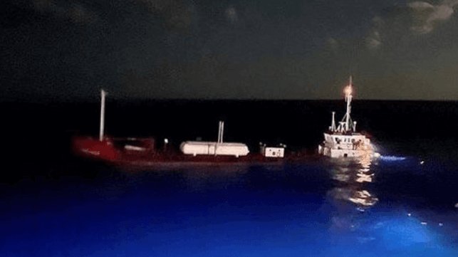 Tanker sinking in blue water at night